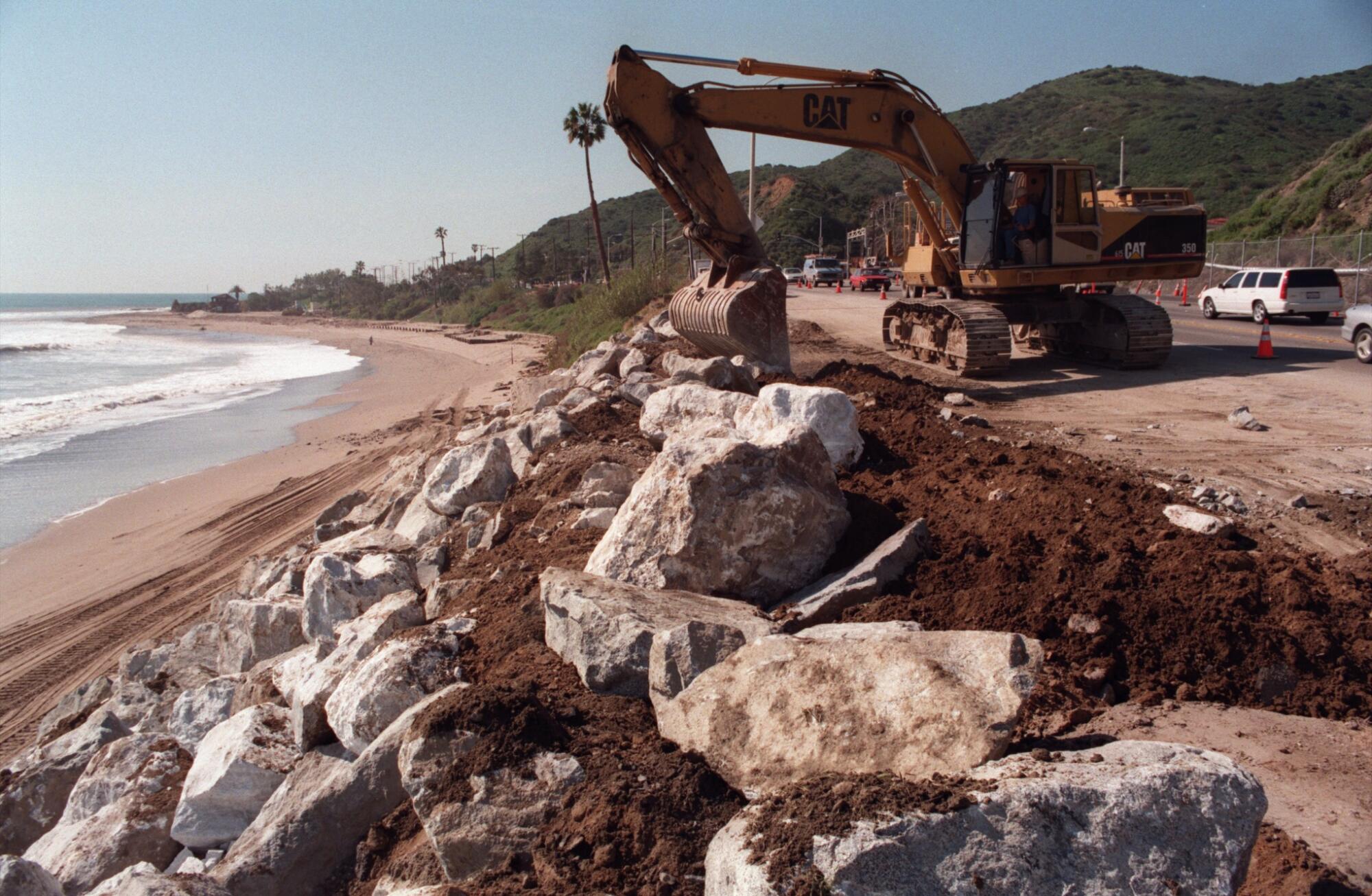 An excavator repositions boulders along the Pacific Coast Highway in Malibu. 