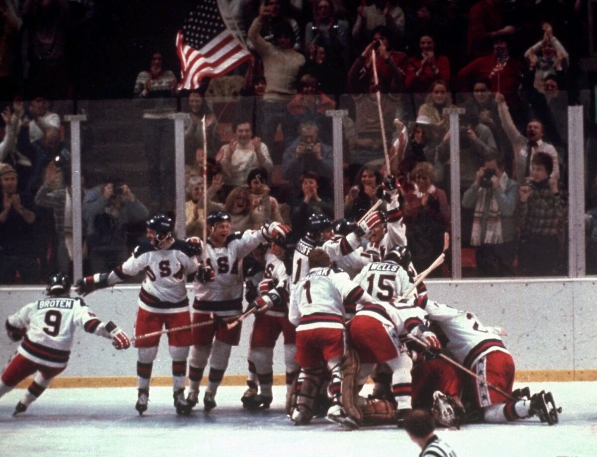 A team of hockey players celebrating on ice.