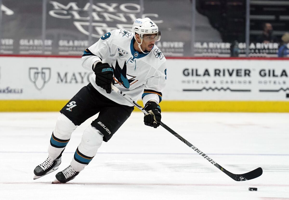 FILE - In this March 26, 2021, file photo, San Jose Sharks left wing Evander Kane moves the puck during the team's NHL hockey game against the Arizona Coyotes in Glendale, Ariz.T he NHL says it will investigate an allegation made by Kane’s wife that he bets on his own games and has intentionally tried to lose for gambling profit. (AP Photo/Rick Scuteri, File)