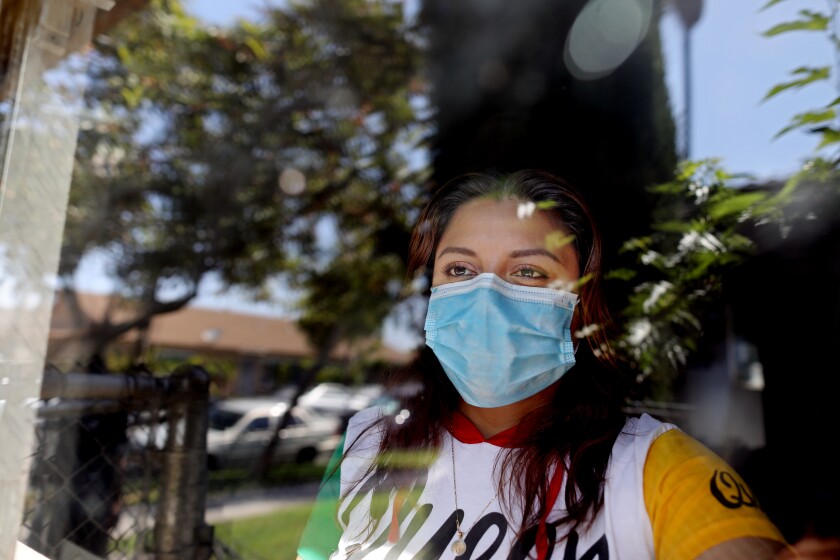 ORANGE, CA -- MAY 14: Certified nursing assistant Rosa Arenas, 32, has been home quarantining since May 2 after testing positive for COVID-19, at her apartment on Thursday, May 14, 2020, in Orange, CA. Arenas has been out of work since and worries she will not get paid for time off needed to recover from the disease. Her lone consolation is she did not spread the disease to her two children. She works at Orange Healthcare & Wellness Centre, that provides 24 hour nursing care to their residents. (Gary Coronado / Los Angeles Times)