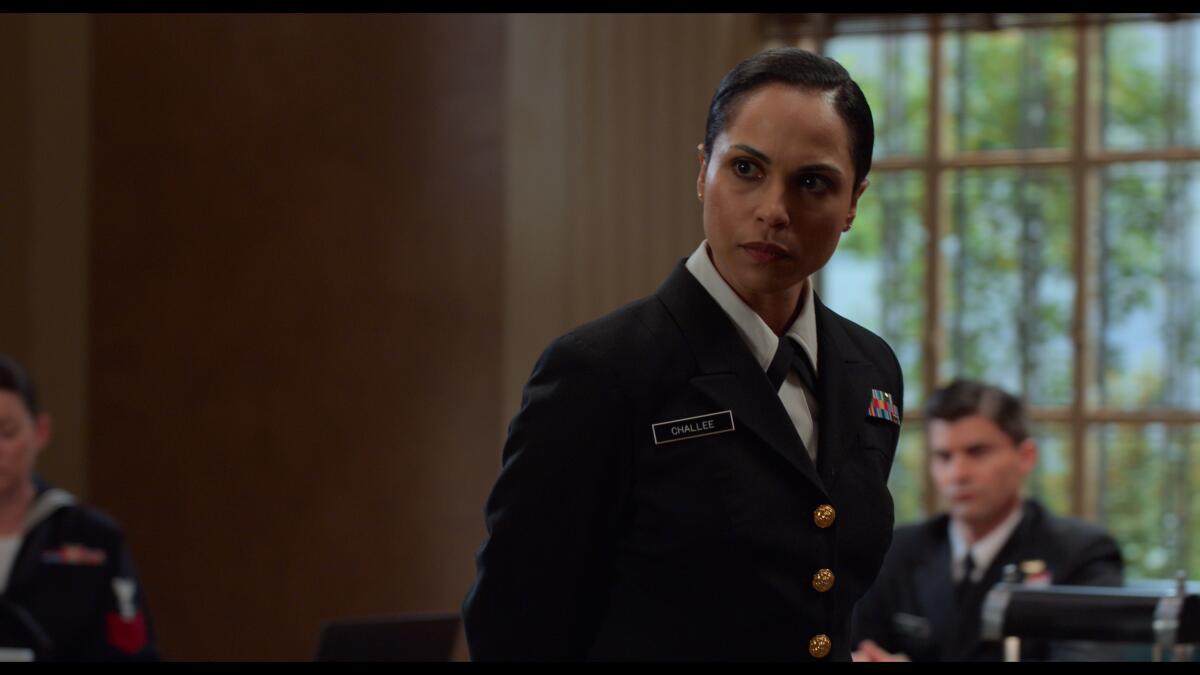 A woman in military uniform, in a courtroom, looking stern.