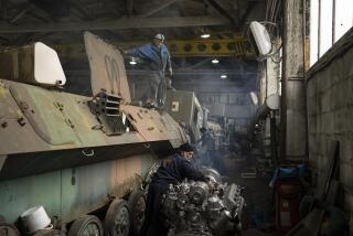 A mechanic repairs the engine of a Ukrainian armoured personnel carrier at a tank repair shop in the Kyiv region, Ukraine, Friday, Oct. 20, 2023. (AP Photo/Bram Janssen)