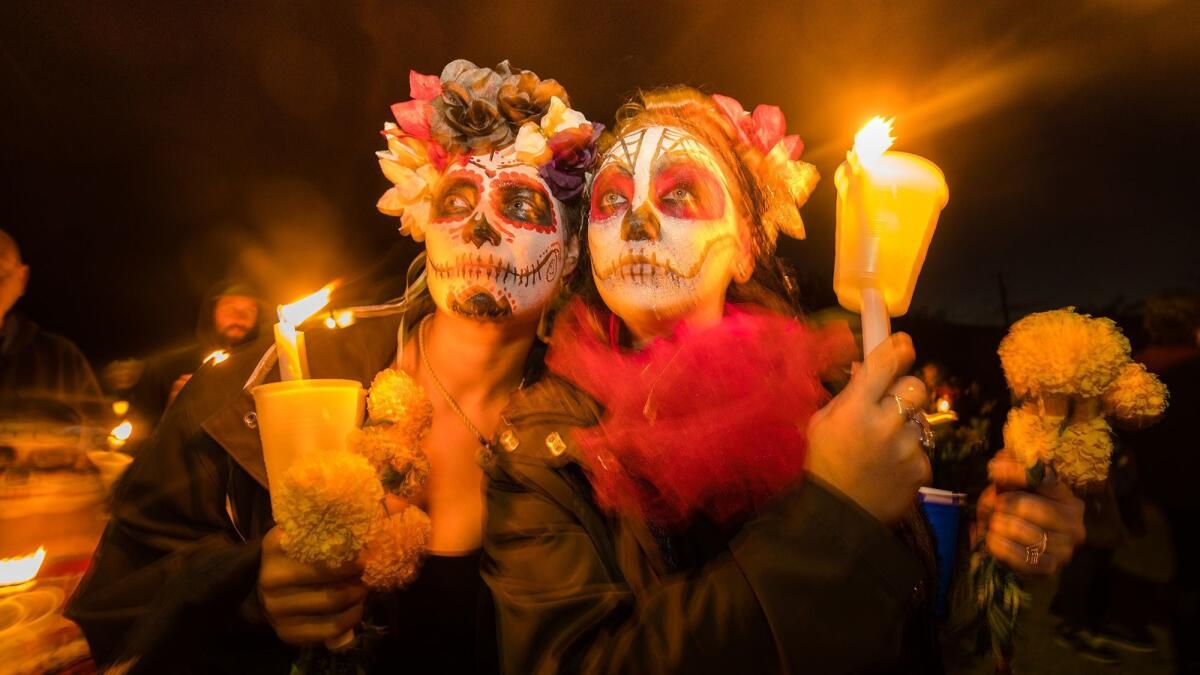 Some of this year's celebrants in Hornitos, with painted faces and marigolds, remember the dead.