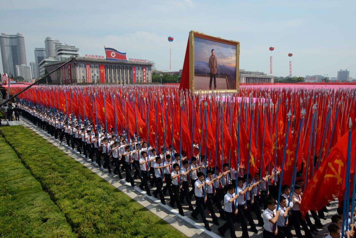 North Koreans carry a portrait of former leader Kim Jong Il during a military parade in Pyongyang on Saturday marking the 60th anniversary of the Korean War armistice.