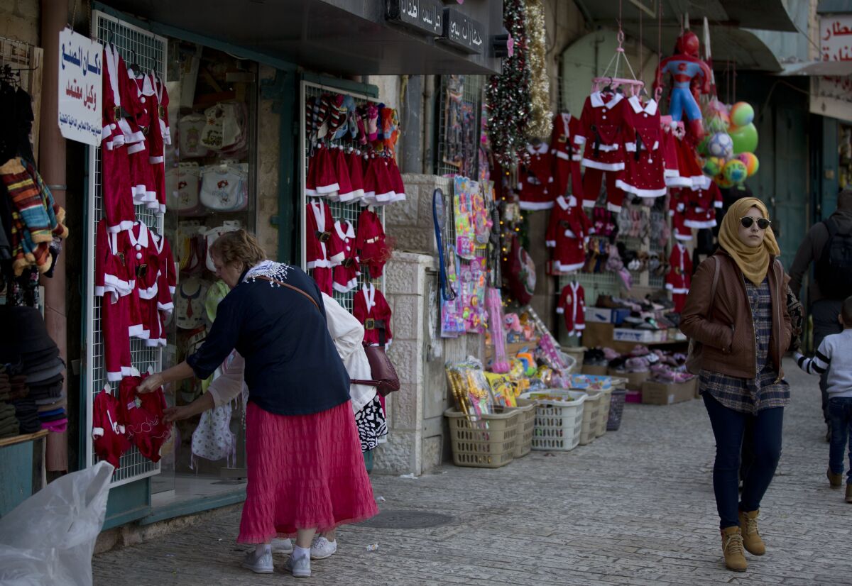 Visitors shop near the Church of the Nativity, which tradition holds to be the birthplace of Jesus Christ, in the West Bank city of Bethlehem on Dec. 5, 2019.