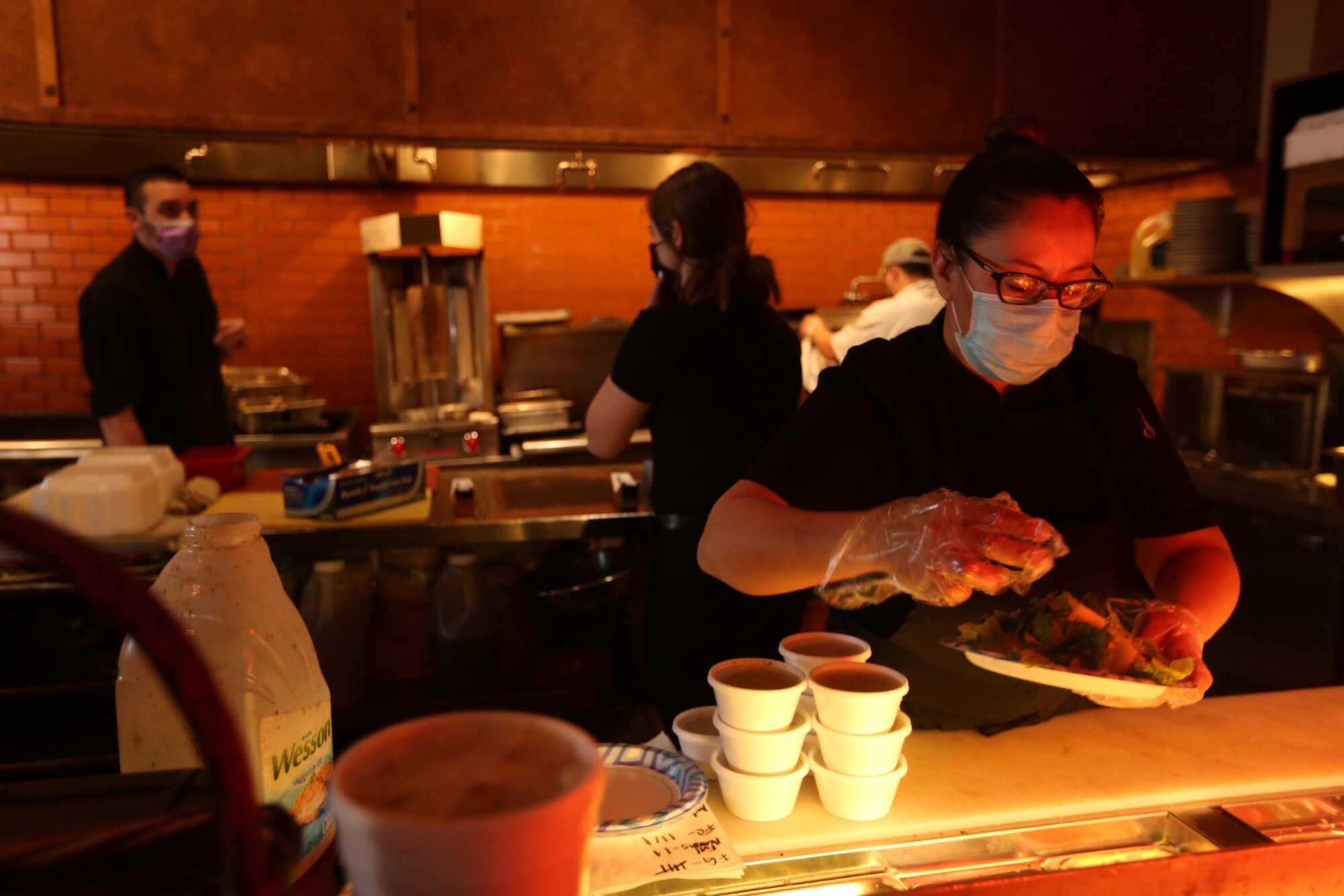 Chef Edith Icaguirre, right, prepares a take out order at Papapavlos Bistro and Bar in the Lincoln Center in Stockton.