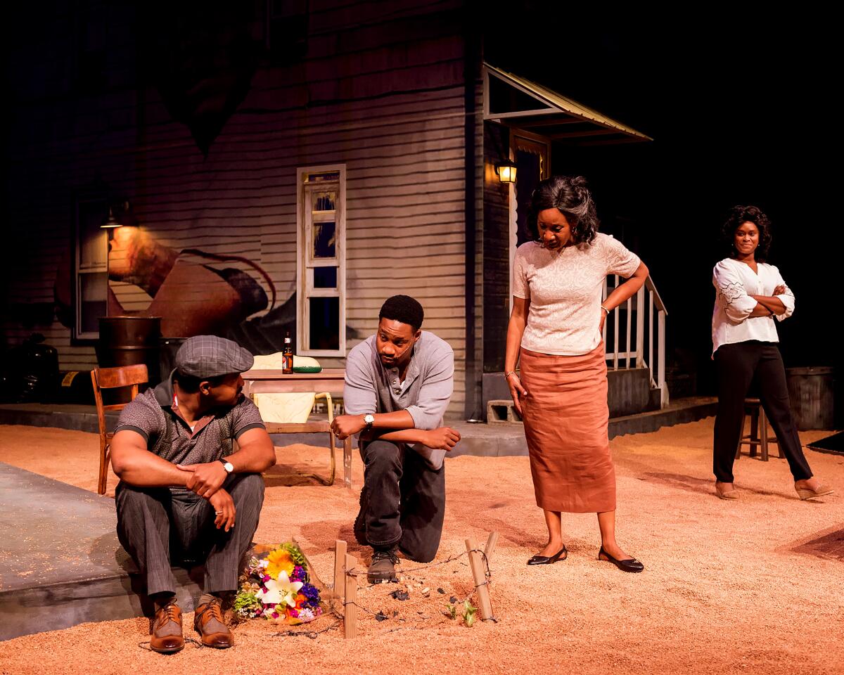 Two men and two women gather in a backyard conversation in a scene from  "King Hedley II" at A Noise Within.