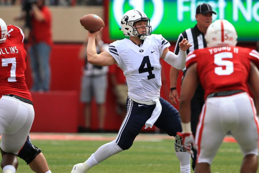 BYU quarterback Taysom Hill (4) throws between Nebraska linebackers during the first half of the game on Saturday. Hill is out for the season.