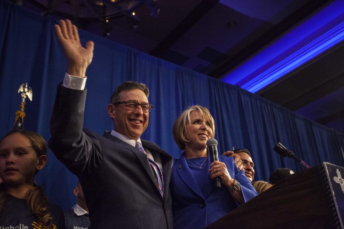 FILE - Then-New Mexico Governor-elect Michelle Lujan-Grisham delivers her acceptance speech alongside her fiancé Manny Cordova in Albuquerque, New Mexico, on Nov. 6, 2018. New Mexico Gov. Michelle Lujan Grisham is getting married, and Vice President Kamala Harris has been picked to officiate. Lujan Grisham, who is running for reelection, will be tying the knot with her fiancé Manny Cordova on May 21, 2022, in Washington. (AP Photo/Juan Labreche, File)