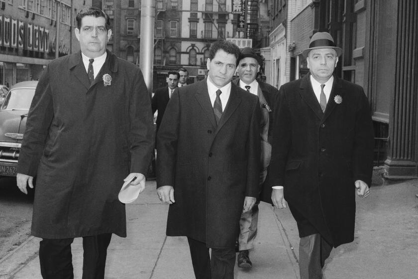 John "Sonny" Franzese, center, is escorted to the Elizabeth Street police station in New York, after his arrest on a 43-count gambling indictment.
