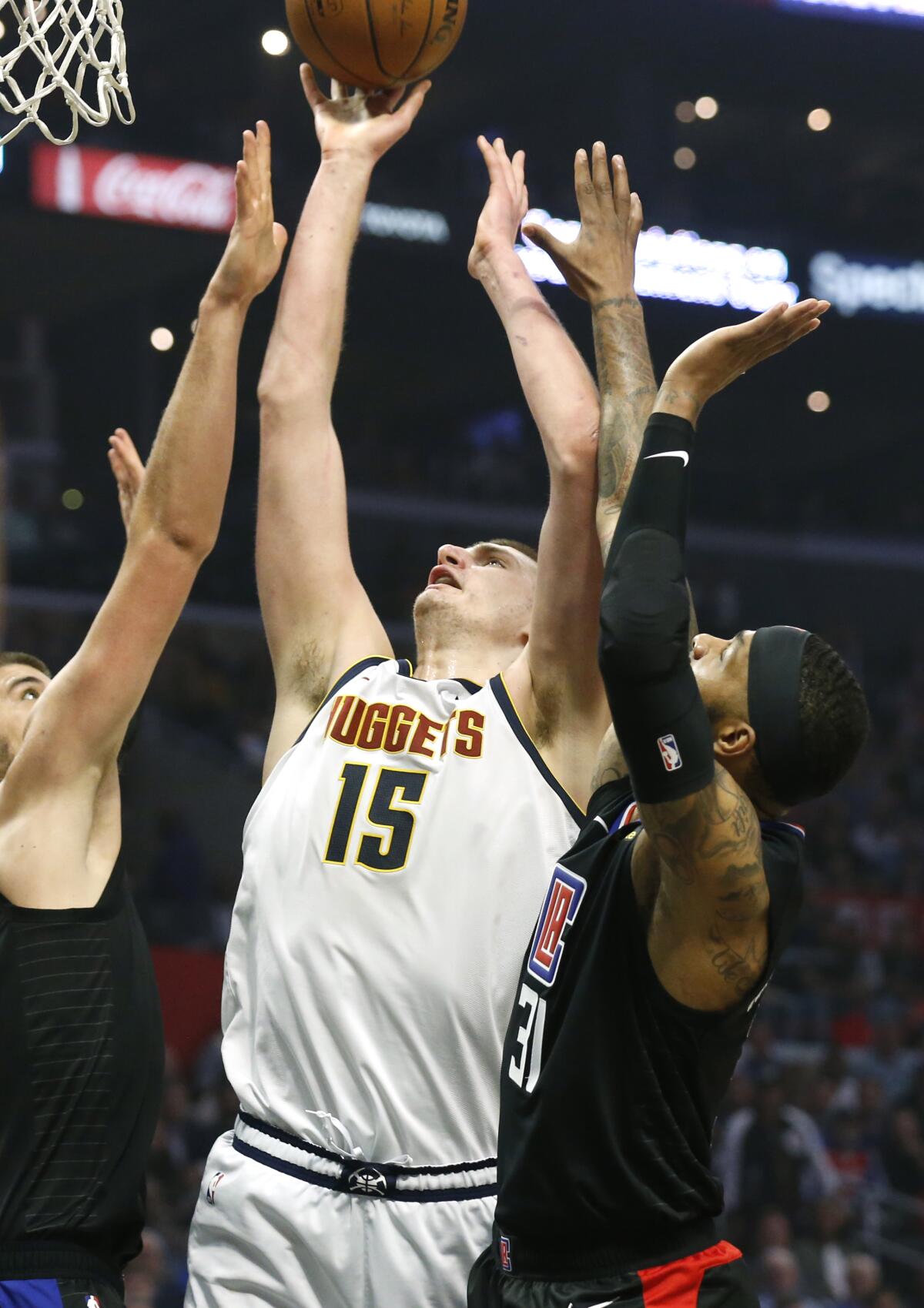 Nuggets center Nikola Jokic (15) tries to score inside against Clippers center Ivica Zubac, left, and forward Marcus Morries (31) during the first half of a game on Feb. 28, 2020, at Staples Center.