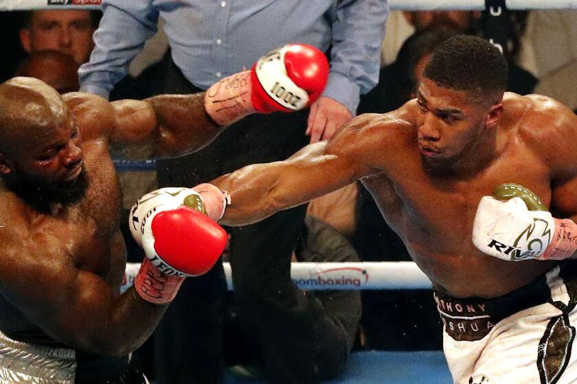 Cameroon-born Carlos Takam (L) recoils from a straight right from Britain's Anthony Joshua (R) during their world heavyweight title fight at The Principality Stadium in Cardiff on October 28, 2017. Joshua stopped Takam in 10th round to retain his championship belts. / AFP PHOTO / ADRIAN DENNISADRIAN DENNIS/AFP/Getty Images ** OUTS - ELSENT, FPG, CM - OUTS * NM, PH, VA if sourced by CT, LA or MoD **
