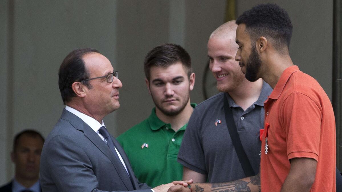 French President Francois Hollande, left, shakes hands with Anthony Sadler next to off-duty U.S. servicemen Spencer Stone, second from right, and Alek Skarlatos, considered heroes for their bravery after they overpowered an attacker on a train from Amsterdam to Paris. (Kenzo Tribouillard / AFP/Getty Images)
