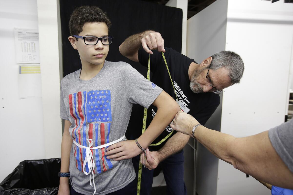 Volunteer Keith Barnum measures Gabriel Elizarraras for a possible role in the 2020 Pageant of the Masters during an open casting call Friday night.