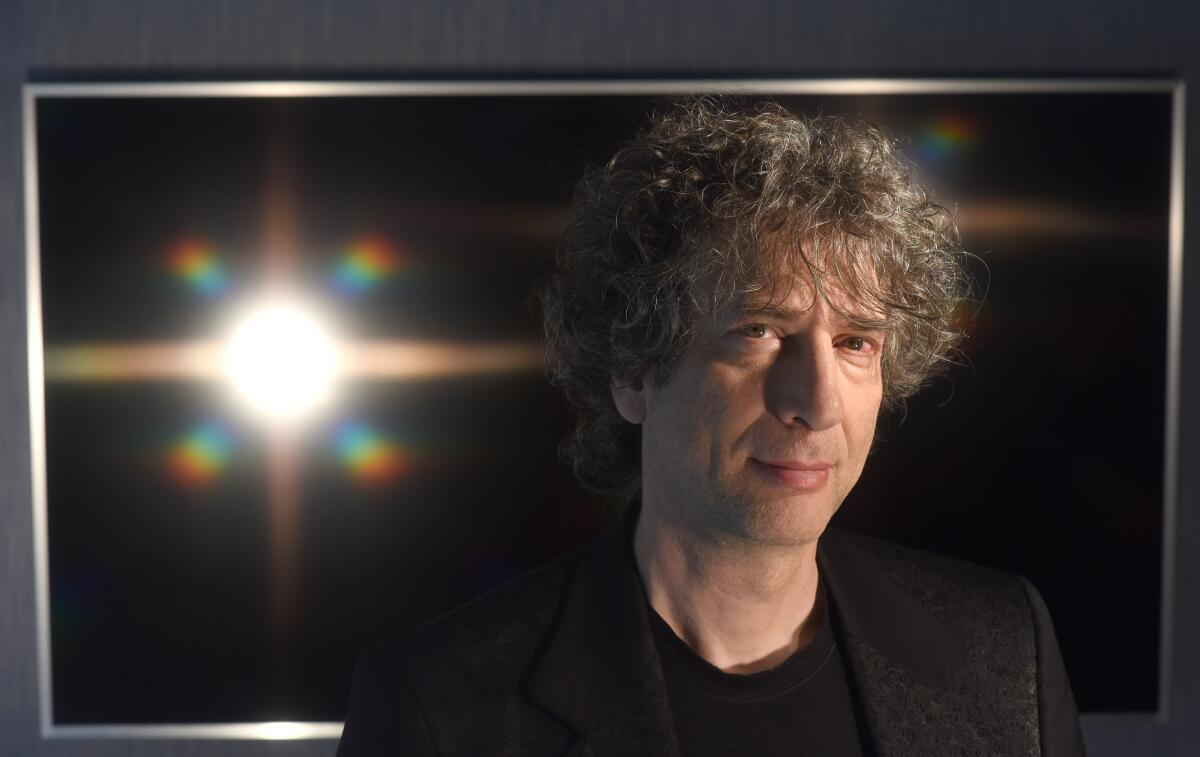 Neil Gaiman next to a bright light