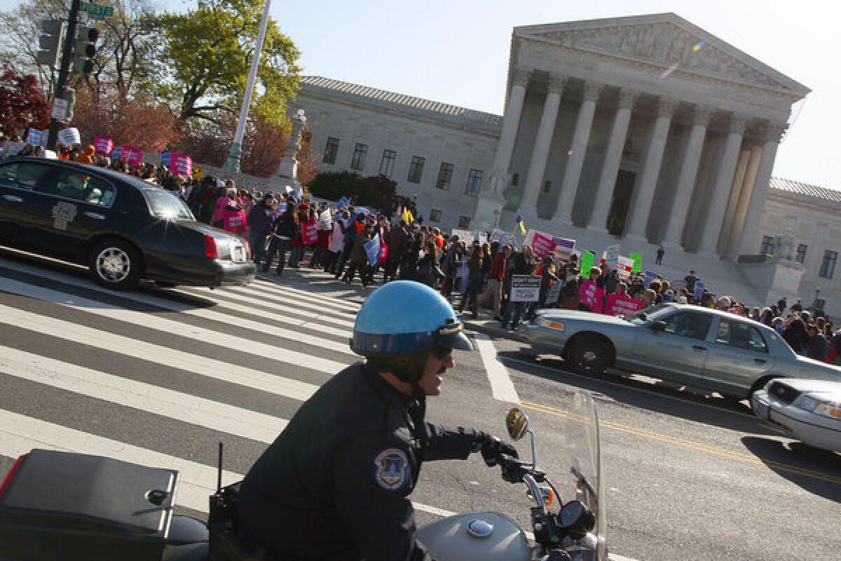 Supporters and opponents of the healthcare law demonstrate outside the Supreme Court.