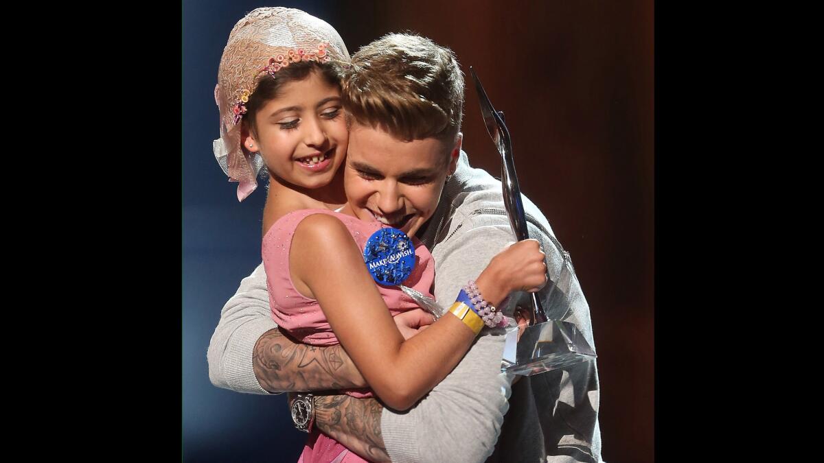 Justin Bieber hugs Make-A-Wish recipient Grace Kesablak onstage at the Young Hollywood Awards on July 27 in Los Angeles. The Biebs earned the Champ of Charity award, which he promptly gave to Grace.