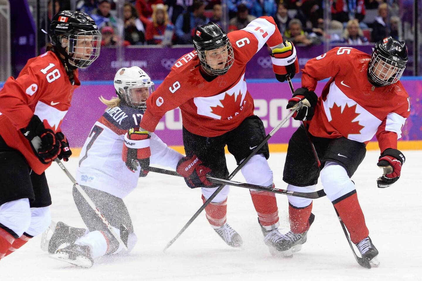 Jocelyne Lamoureux, of the U.S., vies for the puck with Canada's Catherine Ward, Jennifer Wakefield and Melodie Daoust during the women's ice hockey gold medal game.