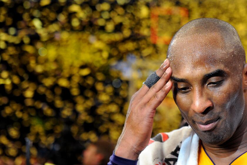 Lakers star Kobe Bryant pauses for a moment as confetti streams down at the Staples Center following his final game on April 13, 2016.