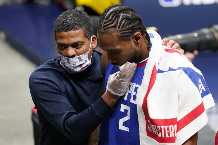 Los Angeles Clippers forward Kawhi Leonard, center, is accompanied off the court during the second half.