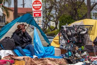 Tierra Signer  waits with her belongings, to get housing under Inside Safe program, along 400 S. San Vicente Boulevard.