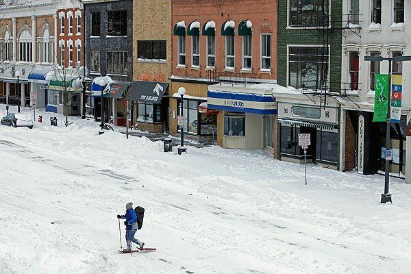 A man uses snowshoes to move through downtown Iowa City as a major winter storm moves through the Midwest.