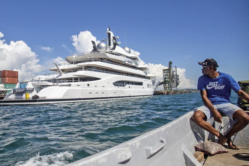 FILE - Boat captain Emosi Dawai looks at the superyacht Amadea where it is docked at the Queens Wharf in Lautoka, Fiji, on April 13, 2022. On May 5, five U.S. federal agents boarded the massive Russian-owned superyacht Amadea that was berthed in Lautoka harbor in Fiji in a case that is highlighting the thorny legal ground the U.S. is finding itself on as it tries to seize assets of Russian oligarchs around the world. (Leon Lord/Fiji Sun via AP, File)