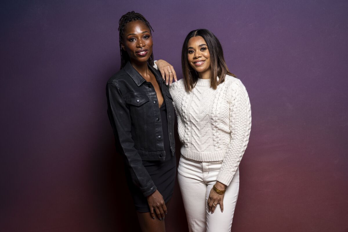 A woman wearing denim, left, and a woman wearing all white pose for a picture