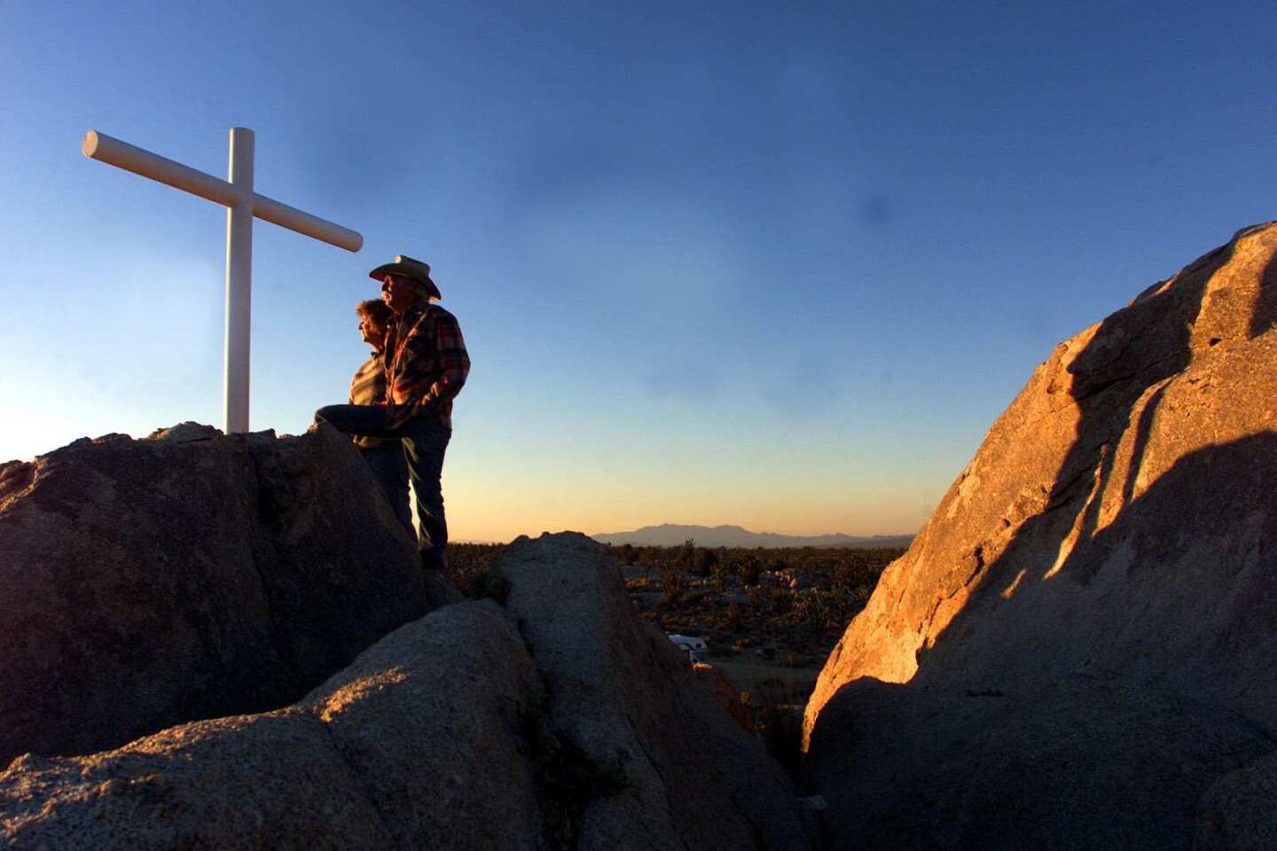 Henry and Wanda Sandoz at the cross on Sunset Rock in the Mojave National Preserve. The cross, erected in 1934 as a tribute to World War I veterans, was stolen, but the Sandozes plan to raise a new one on the site.