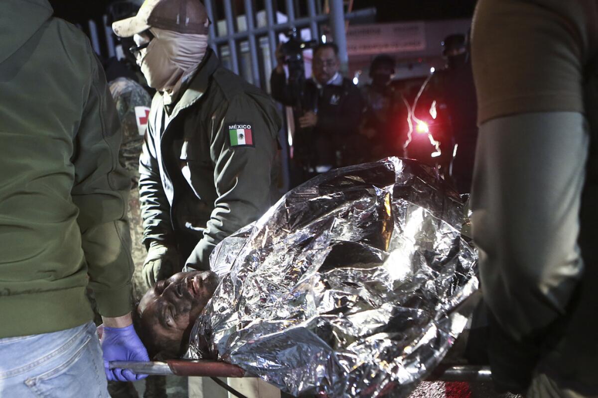 ARCHIVO - Paramédicos llevan a un migrante que resultó herido en el incendio mortal