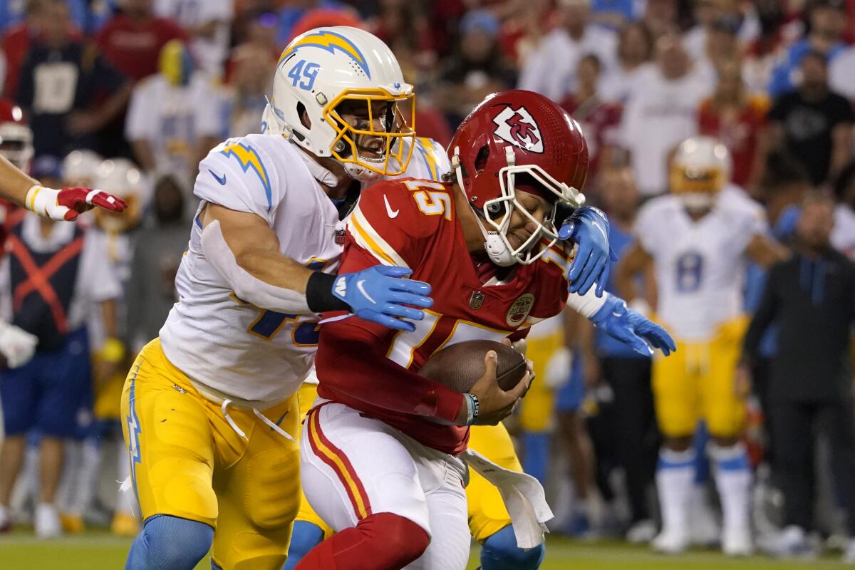 Chargers linebacker Drue Tranquill grabs Chiefs quarterback Patrick Mahomes by the shoulders while making a sack.