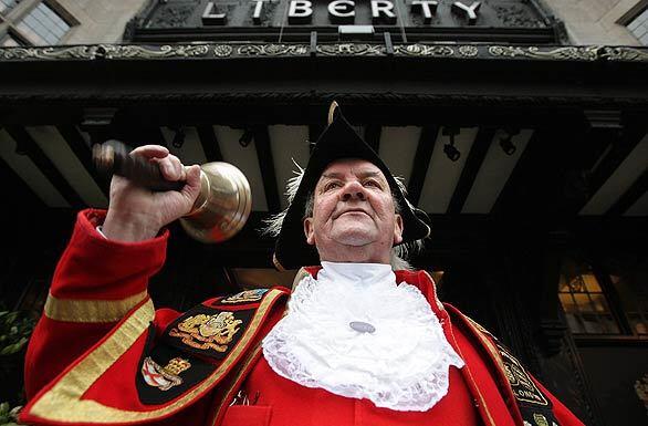 Peter Moore, town crier to the city of Westminster, announces extended early-morning opening hours outside the Liberty department store on Regent Street in London. Many West End shops are opening early in a bid to entice Christmas shoppers who want to avoid the notoriously busy street during peak hours.