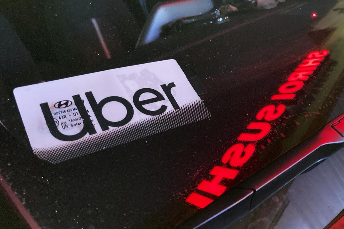 An Uber sign is displayed inside a car