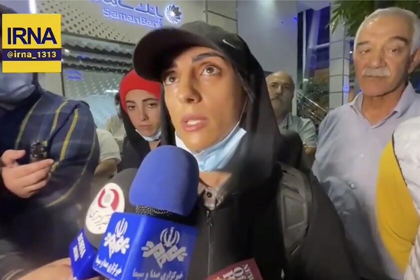 In this image taken from video by Iran's state-run IRNA news agency, Iranian competitive climber Elnaz Rekabi speaks to journalists in Imam Khomeini International Airport in Tehran, Iran, Wednesday, Oct. 19, 2022. Rekabi received a hero's welcome on her return to Tehran early Wednesday, after competing in South Korea without wearing a mandatory headscarf required of female athletes from the Islamic Republic. Rekabi has described her not wearing a hijab as "unintentional" after Farsi-language media abroad raised concerns about her safety. (IRNA via AP)