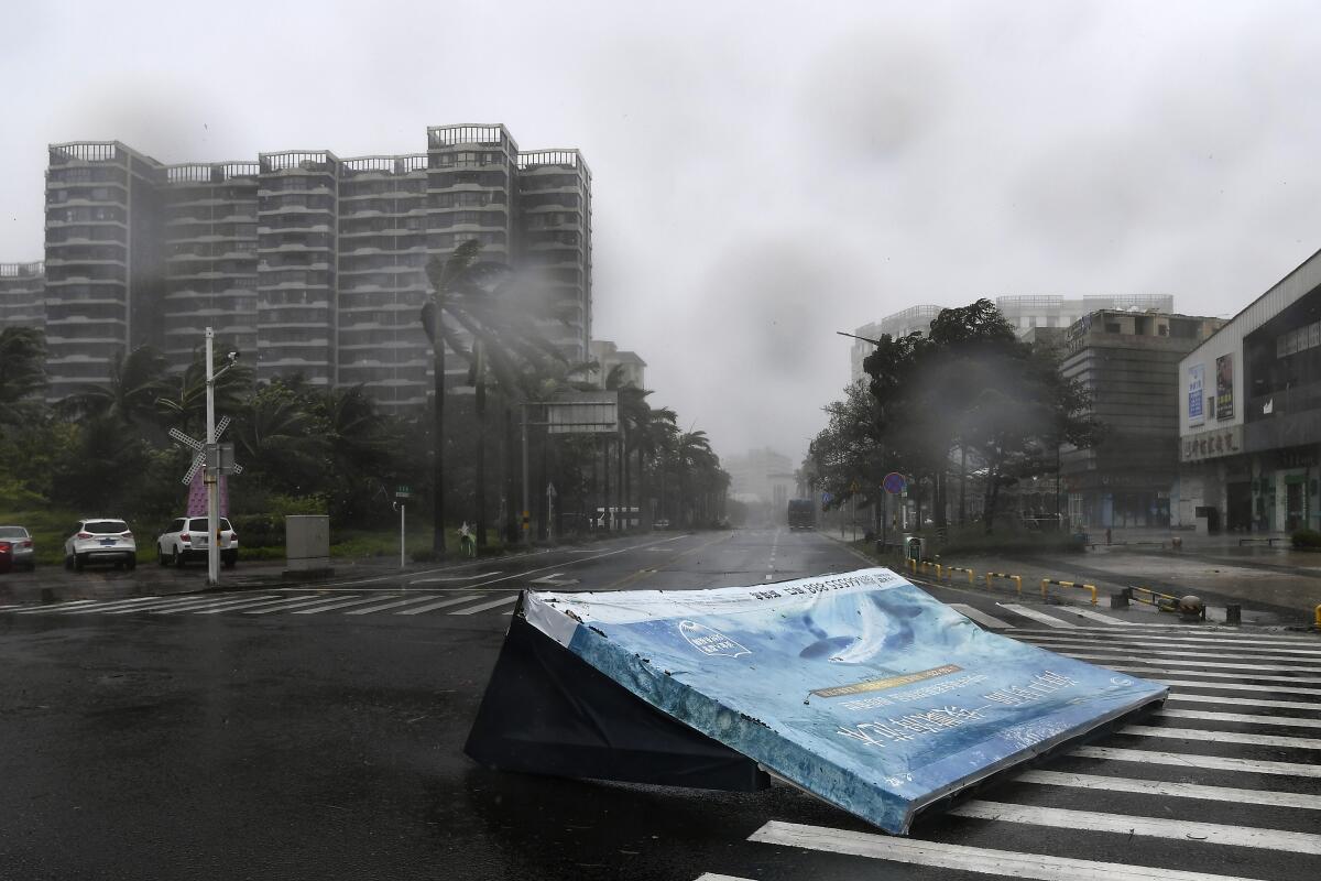 A billboard lies on a road amid a storm.