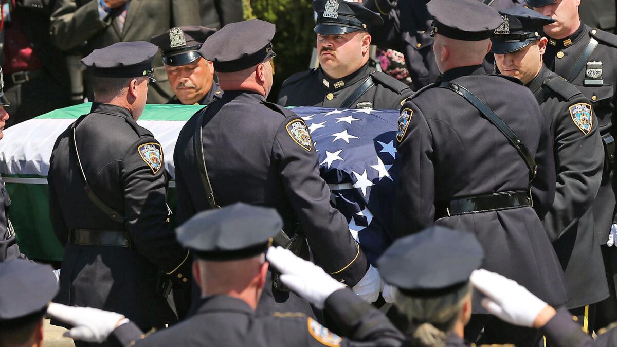 The casket for fallen New York City police officer Brian Moore is brought into a Long Island church.