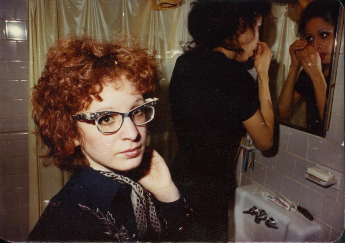 A photo of Nan Goldin and another woman in a bathroom in the 1970s
