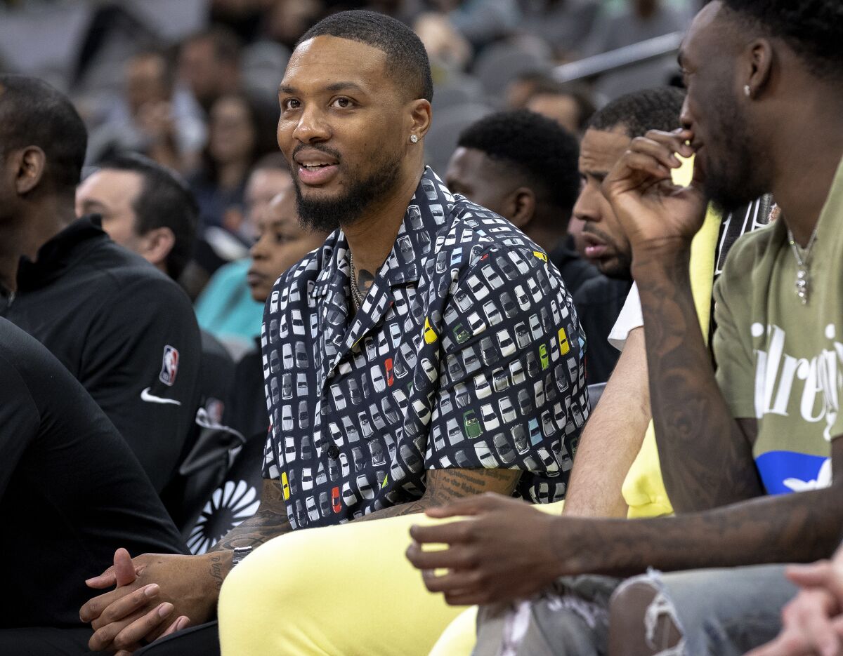 Portland Trail Blazers guard Damian Lillard sits on the bench during the second half of the team's NBA basketball game against the San Antonio Spurs on Friday, April 1, 2022, in San Antonio. Lillard is injured and out for the remainder of the season. (AP Photo/Nick Wagner)
