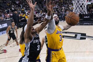 San Antonio Spurs forward Keldon Johnson, left, is blocked by Los Angeles Lakers forward Anthony Davis, right, during the second half of an NBA basketball game in San Antonio, Wednesday, Dec. 13, 2023. (AP Photo/Eric Gay)
