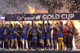 American Alex Morgan holds the trophy beside teammates after they beat Brazil in the CONCACAF Gold Cup women's final