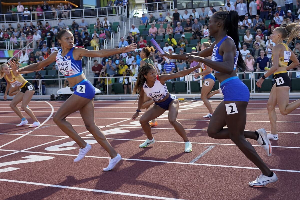 Allyson Felix receives the baton from U.S. teammate Talitha Diggs during a heat in the women's 4x400-meter relay.