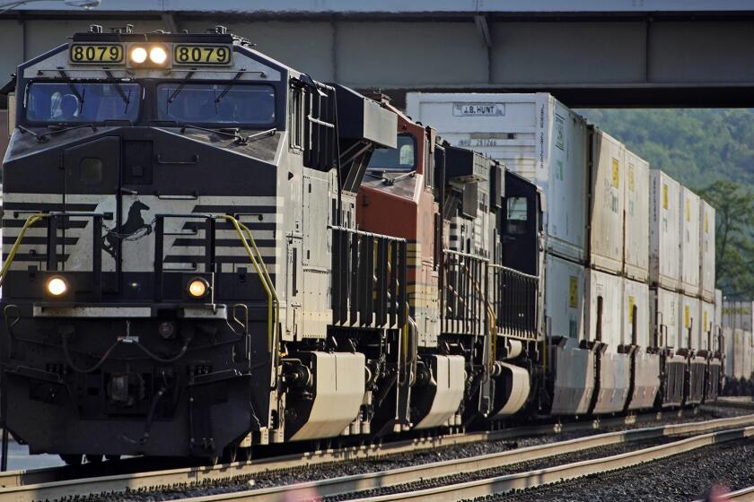 FILE - A Norfolk Southern freight train runs through a crossing on Sept. 14, 2022, in Homestead, Pa. Norfolk Southern reports earnings on Wednesday, April 24, 2024. (AP Photo/Gene J. Puskar, File)