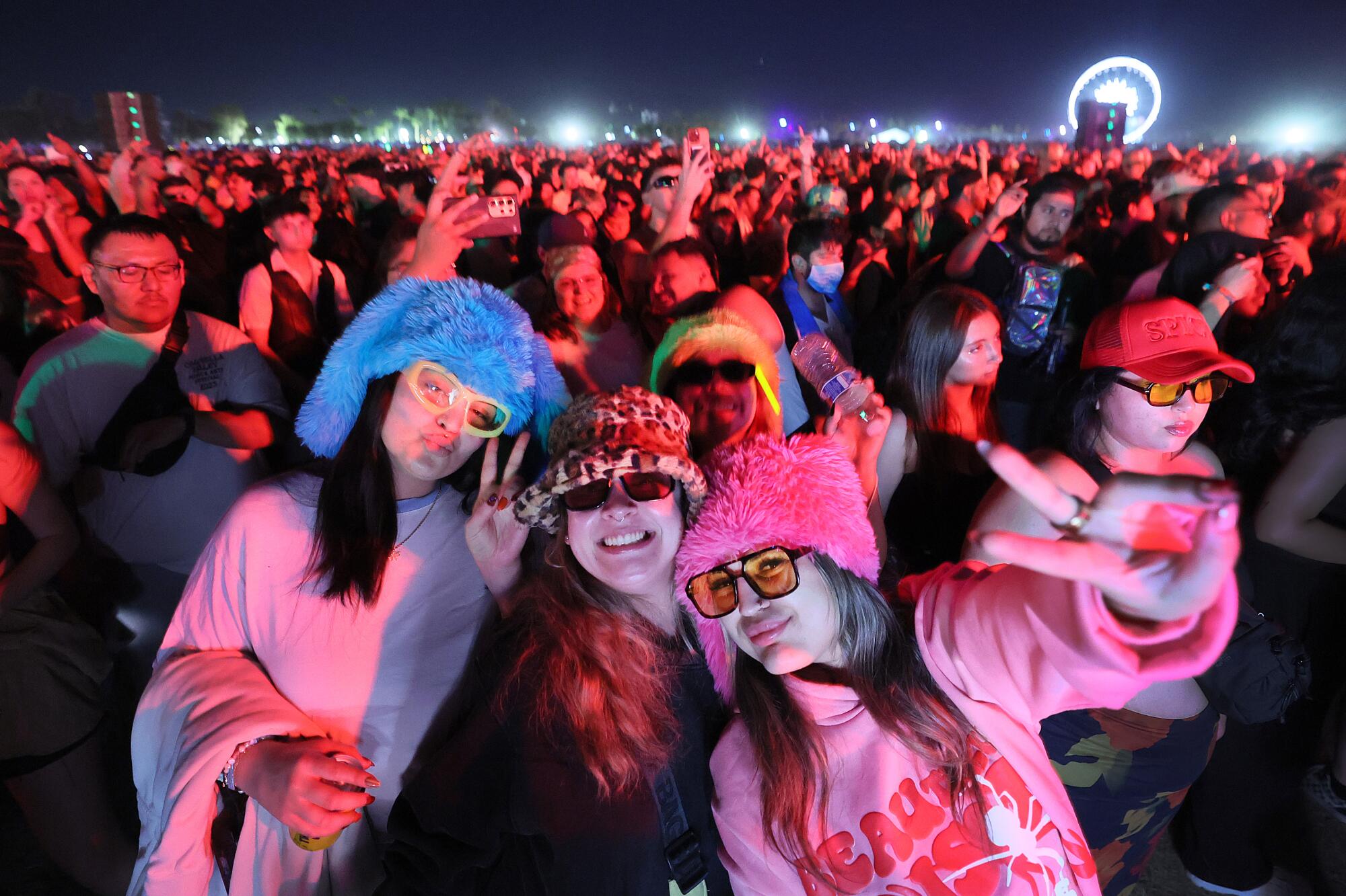 Music lovers sporting festive hats groove astatine Coachella successful Indio.