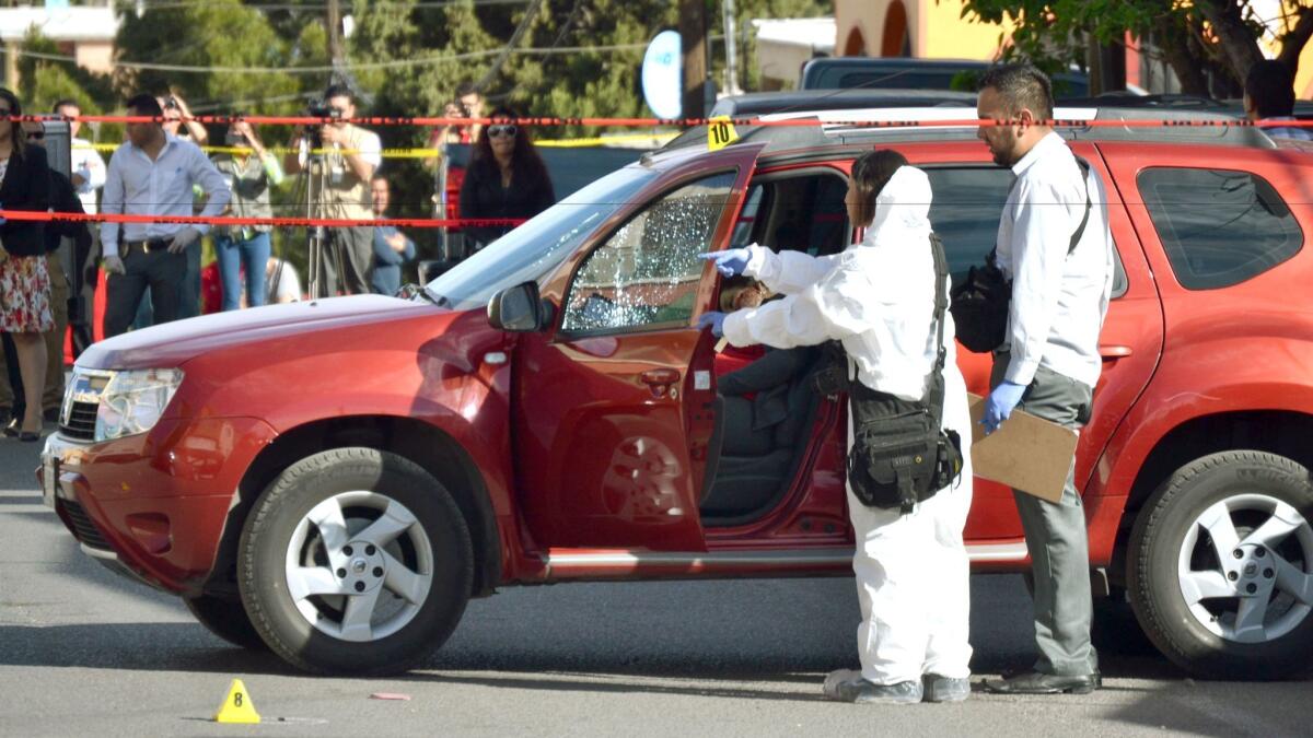 Mexican forensic experts inspect journalist Miroslava Breach's vehicle after she was killed last month. Breach was a reporter at the Norte newspaper that is closing because of repeated attacks against journalists.