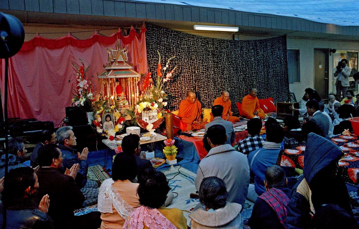 Buddhist priests lead a prayer service with many people attending