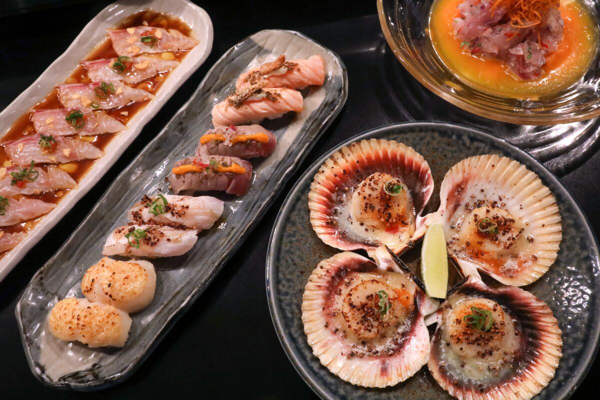 LONG BEACH, CA - FEBRUARY 6, 2024 - - Tiradito Nikkei, from left, Sushi Nikkei Tasting, Grilled Scallops on half shells and Peruvian Cebiche, upper right, are on the menu at Sushi Nikkei in the Bixby Knolls neighborhood of Long Beach on February 6, 2024. (Genaro Molina/Los Angeles Times) Attention Editor: Cebiche is spelled with a “B” at the restaurant.