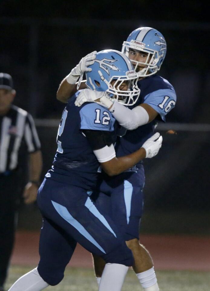 Corona del Mar wide receiver TaeVeon Le (12) is congratulated by Reece Perez after scoring a touchdown against Trabuco Hills.