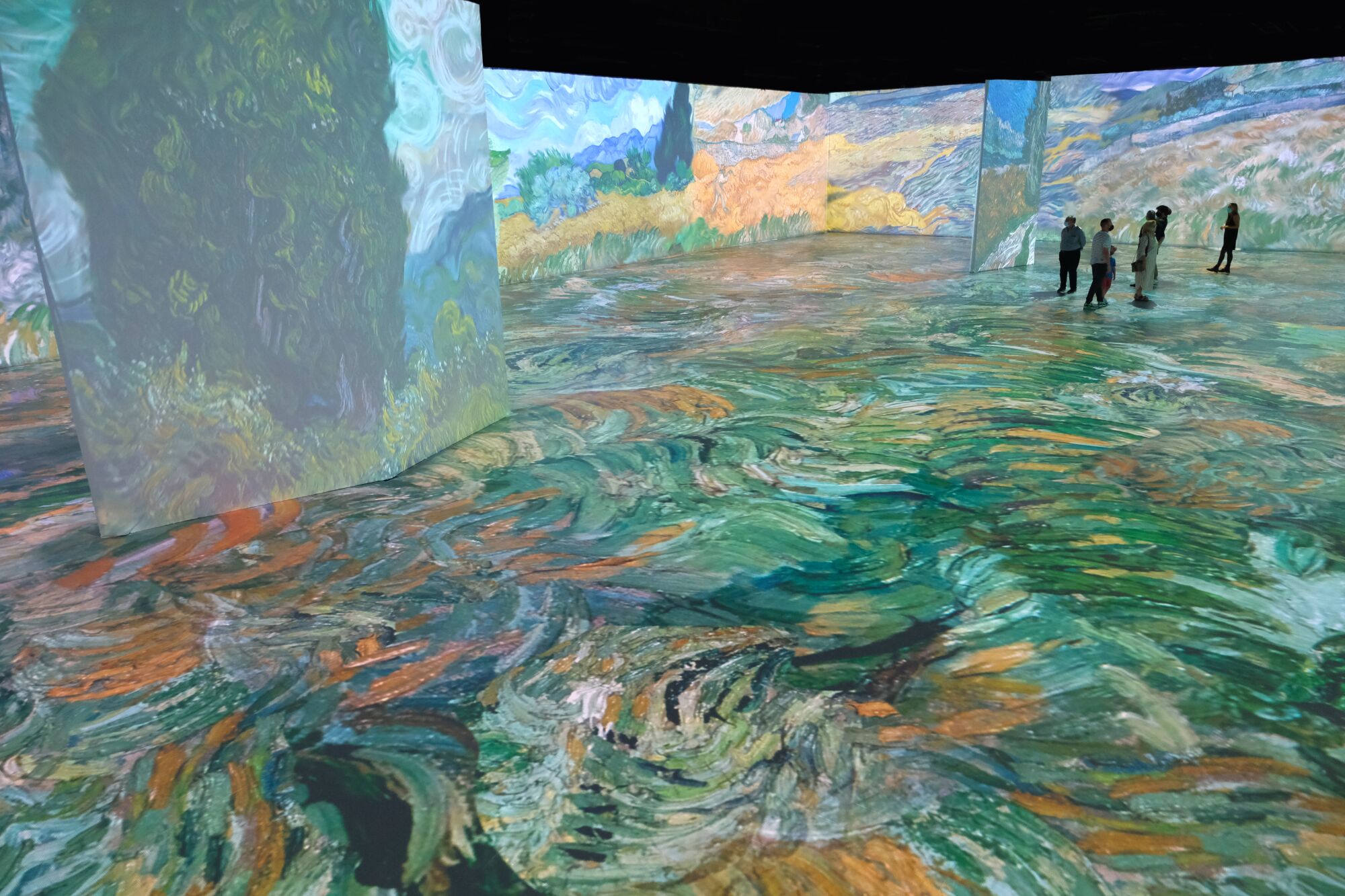 Visitors walk through "Beyond Van Gogh: The Immersive Experience"