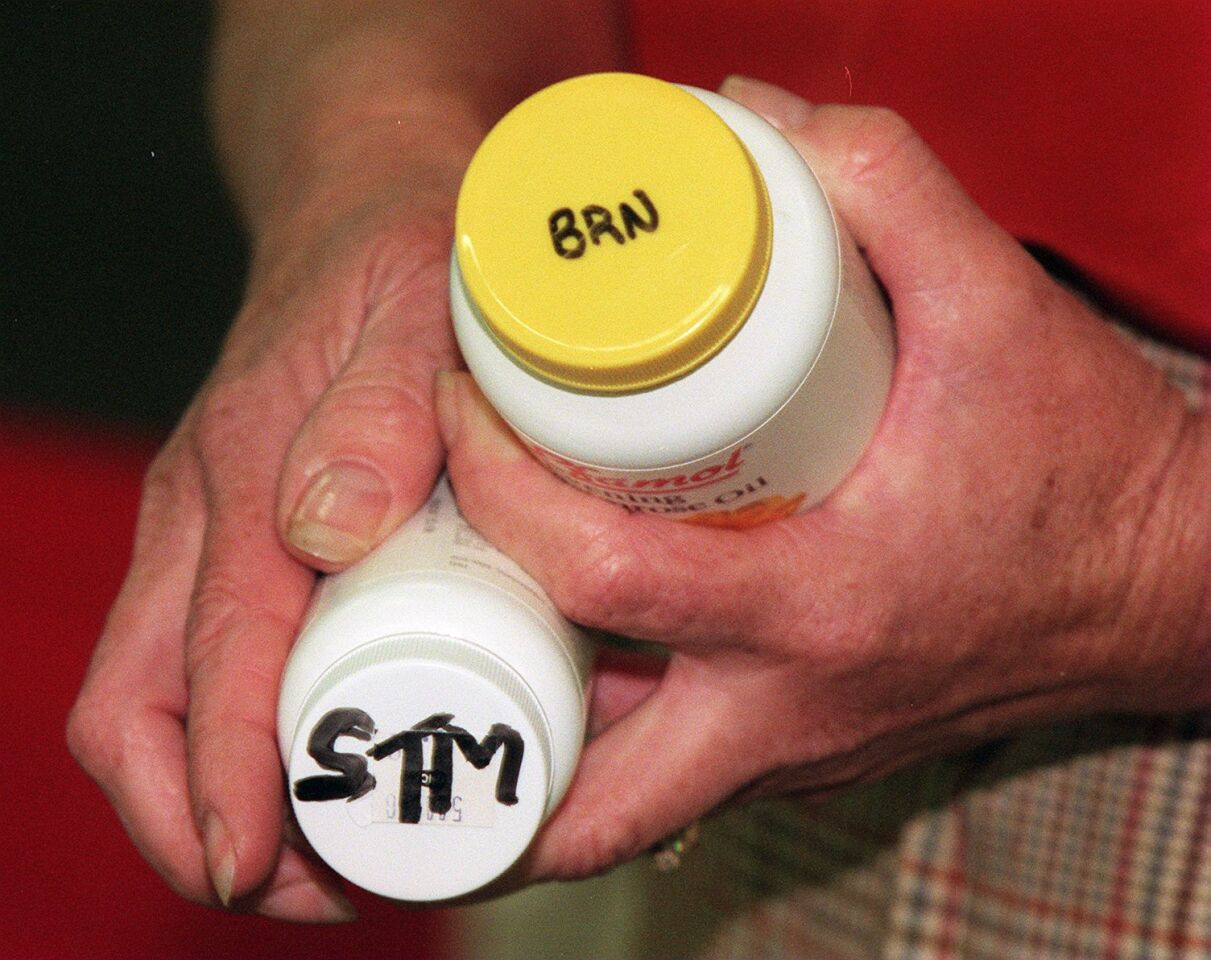 Susan Jamme, the county's deputy public administrator, holds two vitamin bottles that belonged to Heaven's Gate members. Jamme said the three letters on each bottle refer to the name of a group member. The letters do not correspond to their legal names. "BRN" is Norma Jean Nelson. "STM" is Gordon Welch.