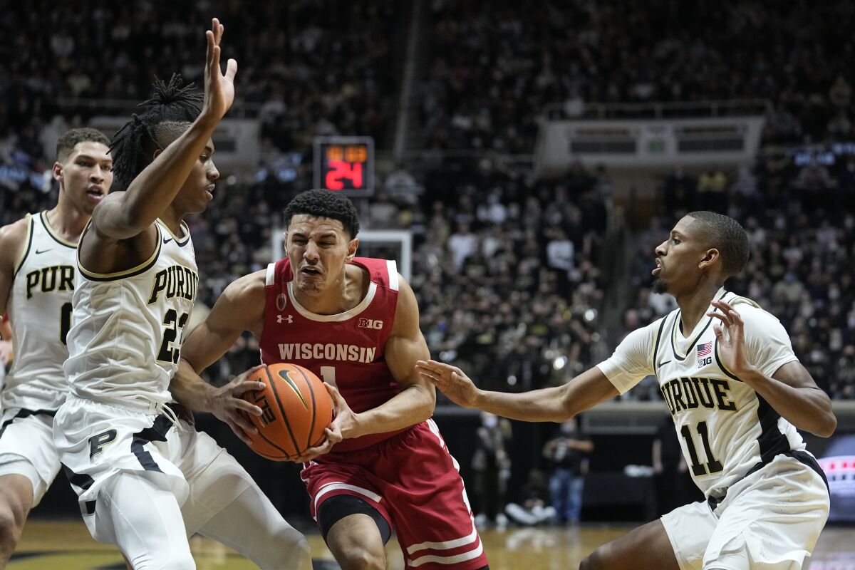 Wisconsin's Johnny Davis (1) goes to the basket against Purdue's Jaden Ivey (23) and Isaiah Thompson (11) during the first half of an NCAA basketball game, Monday, Jan. 3, 2022, in West Lafayette, Ind. (AP Photo/Darron Cummings)
